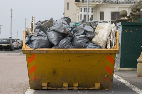Delivery truck and skip at a residential driveway